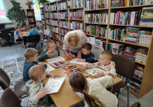 Dzieci starannie wykonują swoje prace plastyczne.