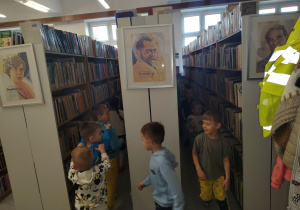 Pociąg prowadzony przez Panią Ilonę przejeżdża pomiędzy bibliotecznymi regałami.