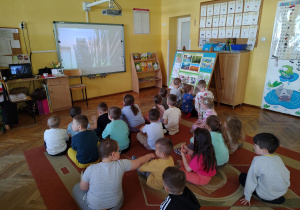 Dzieci oglądają film edukacyjny dotyczący uprawy pieczarek.