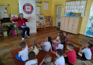 Pani Patrycja pokazuje obrazki z czystymi i brudnymi zębami.