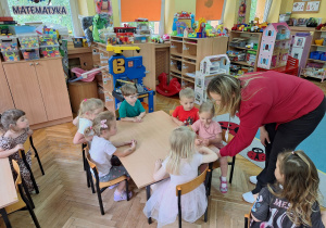 Pani Patrycja wręcza dzieciom naklejki