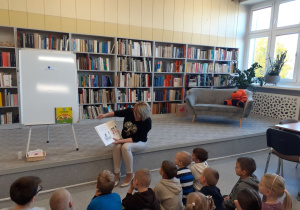 Przedszkolaki słuchają czytanej przez panią Ule książki.