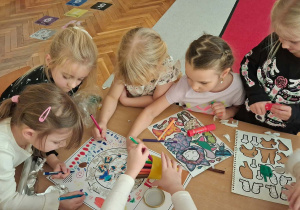 9.Zespół dziewczynek pracuje przy stoliku nad ozdobieniem własnej pralki.