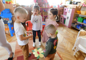 Dzieci - motylki przyleciały do kwiatków.