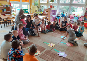 Krasnoludki rozwiązują działania dodawania na „kwiatowych rabatkach”