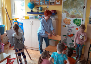 Blanka przypina/odpina klamerki – ptaki, a Maja zapisuje odejmowanie na tablicy.
