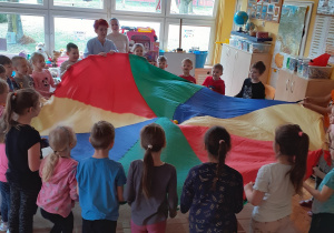 W zabawie z chustą animacyjną Krasnoludki próbują wcelować piłkę – jajko w środek „gniazda".