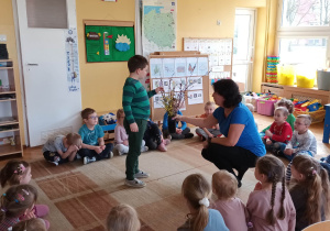 Dzieci biorą udział w obserwacji gałązek w wazonie.
