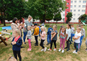 Pani Halinka i pani Natalka rozdają dzieciom medale.