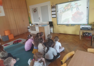Dzieci oglądają z zainteresowaniem film.