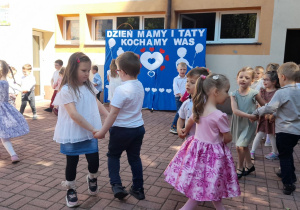 Dzieci tańczą w kółeczkach.