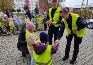 Dzieci wręczają policjantom laurkę.