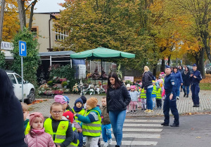 Przedszkolaki przechodzą po pasach.