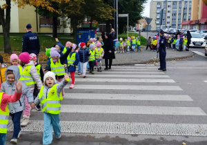 Policjantka nadzoruje przejście po pasach.