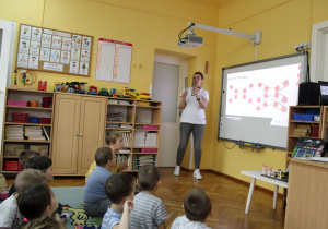 Pani pokazuje dzieciom tory.