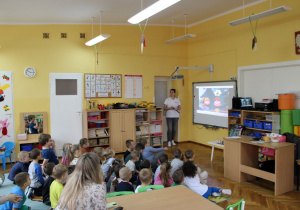 Dzieci oglądają film dotyczący bezpieczeństwa na przejazdach kolejowych.