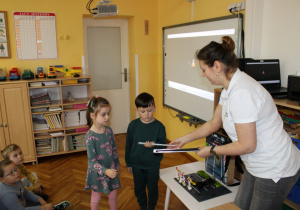 Alicja i Tymon odbierają od Pani odblaski dla przedszkolaków.