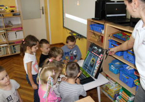 Dzieci oglądają makietę torów kolejowych.