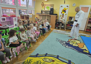 Trener judo pyta się dzieci kto chciałby zapisac się na zajęcia