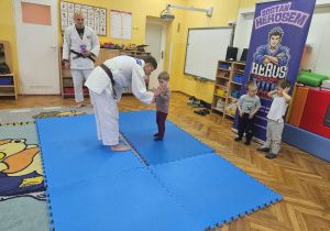Trener judo pokazuje Łucji prawidłowy chwyt