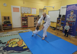 Trener judo pokazuje z Jasiem sztukę walki