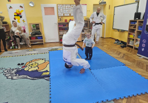 Trener judo stoi na głowie a Nikoś obserwuje