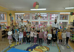 Sportowcy pozują do zdjęcia z dziećmi.