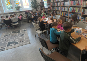 Dzieci kolorują obrazki przedstawiające różne zawody.