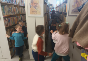Pani Ilona oprowadza dzieci po bibliotece.