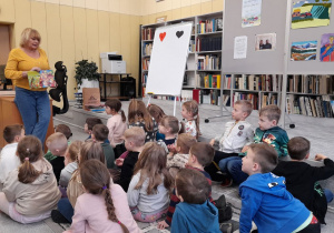 Dzieci oglądają ilustrację z bajki: Jaś i Małgosia.