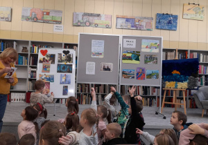 Leon przypina Czerwonego Kapturka na tablicy po stronie z dobrym sercem.