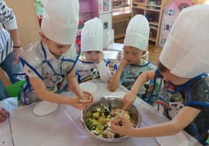 Kornela i Antek K. przyglądają się jak Anastazja i Armin dokładają miód do sałatki.