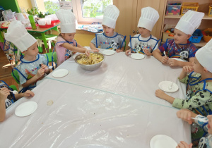 Dzieci nie mogą się doczekać kiedy Ada wymiesza wszystkie składniki sałatki.