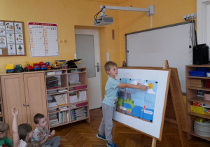 Antek pokazuje dzieciom przyczynę parowania wody z rzeki.