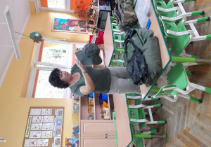 Pani Renata prezentuje dzieciom czapkę wędkarską.