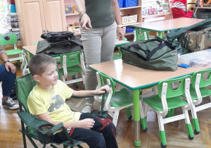 Franek sprawdza, czy krzesełko wędkarza jest wygodne.