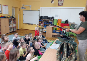 Pani Renata demonstruje dzieciom rozkładanie wędki.