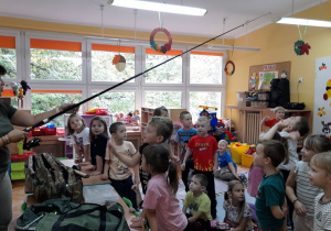 Dzieci podziwiają wędkę.