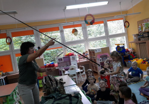 Ada trzyma wędkę i próbuje kręcić kołowrotkiem.