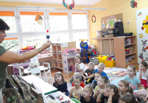 Dzieci oglądają spławik, który trzyma Pani Renata.