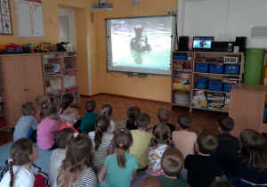 6-latki oglądają film o tym, jak działa rozrzutnik do zanęt Boatman.