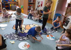 Przedszkolaki obserwują w skupieniu łowienie ryb.