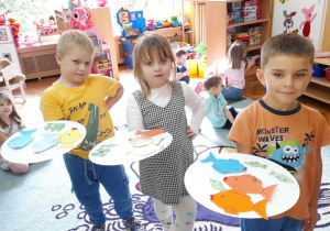 Dzieci pokazują złowione rybki.