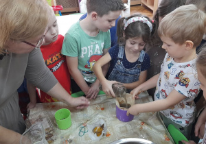 Maja i Antek przelewają odbarwioną wodę przez podwójny filtr do kawy.