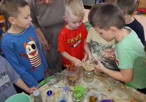 Klemens przelewa brudną wodę przez filtr z kamieni, piasku i wacików.