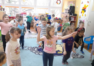 Przedszkolaki naśladują ruchem tańczące żurawie.