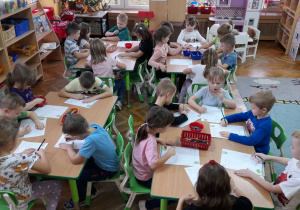 "Misiaczki" wykonują zadanie na karcie pracy, łącząc kropki tak, by powstał ptak.