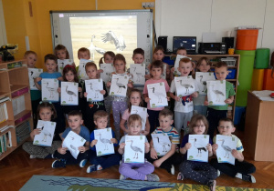 Dzieci prezentują wykonane obrazki z żurawiem.