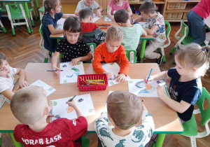 Przedszkolaki kolorują ilustrację według wzoru.