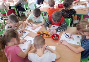 Dzieci starannie dobierają kolory do obrazka.